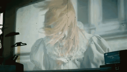 a woman with long blonde hair is projected on a wall