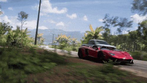 a red sports car is driving on a dirt road