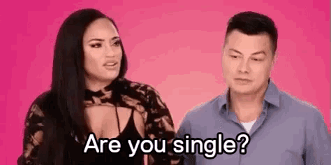a man and a woman are standing next to each other on a pink background .