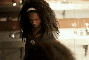 a woman with curly hair is wearing a black shirt that says always on it