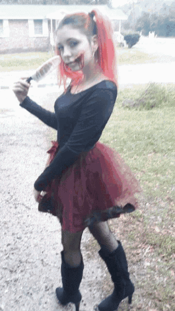 a girl with red hair is holding a knife in her hand