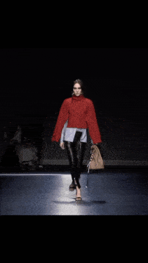 a woman is walking down the runway wearing a pair of black heels