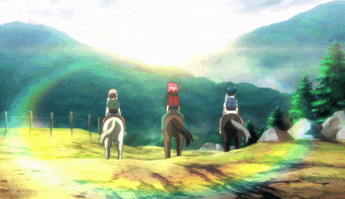 three people riding horses on a dirt road with mountains in the background