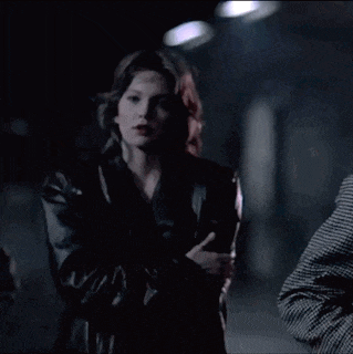 a man and a woman are standing in a dark room