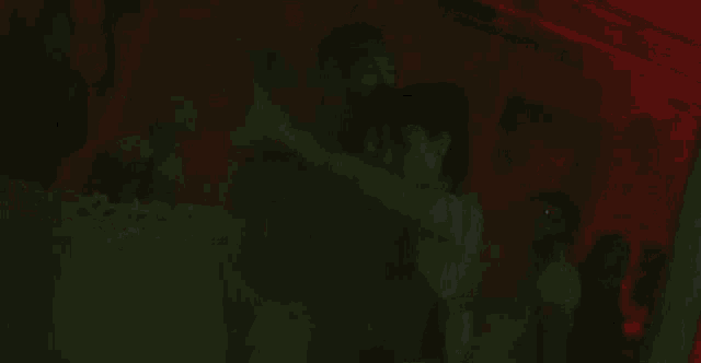 a man and a woman are kissing in a room with smoke coming out of it .