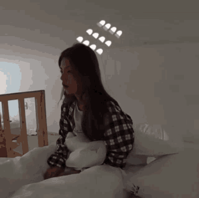 a woman in a plaid shirt is laying in bed
