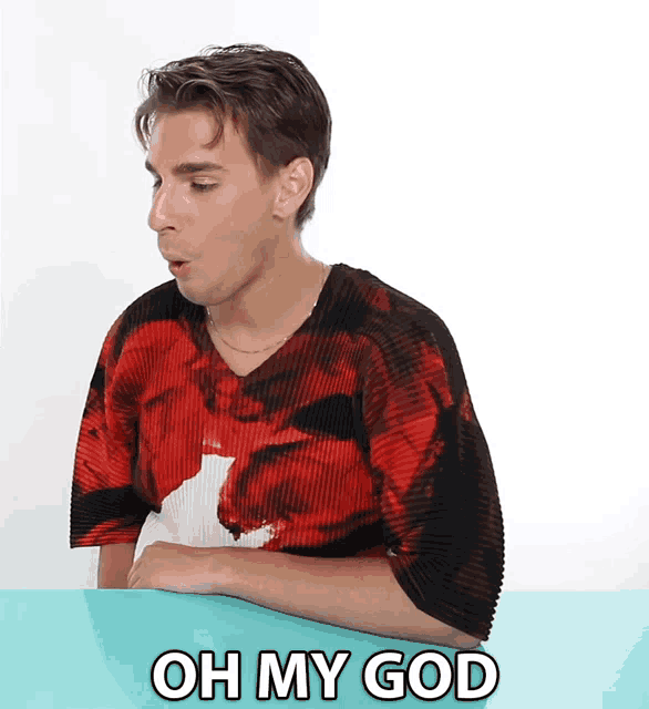 a man wearing a red and black shirt with the words oh my god on the bottom