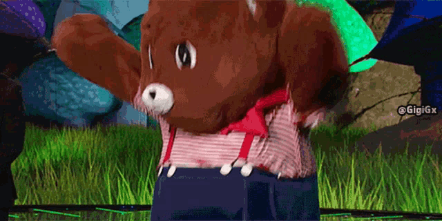 a teddy bear in a striped shirt and suspenders