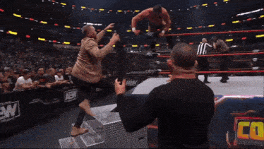 a man is standing in front of a crowd at a wrestling event .