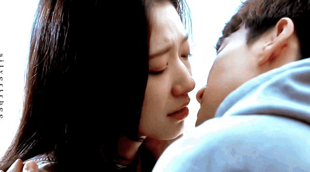 a close up of a man kissing a woman 's forehead with the words silly truths visible