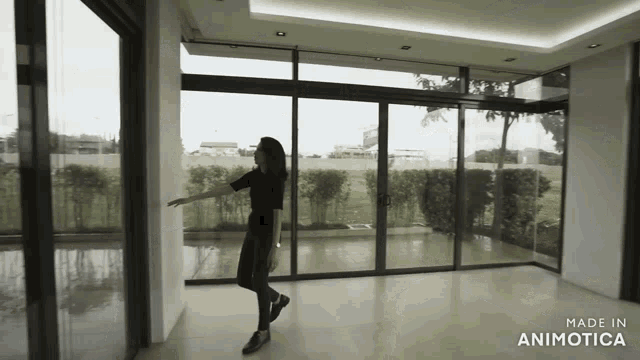 a woman is standing in an empty room with the words made in animatica on the bottom