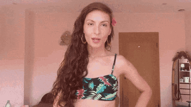 a woman in a bikini top is standing in front of a door