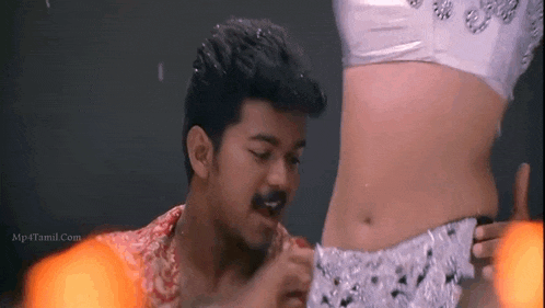 a man is touching a woman 's stomach while she dances .