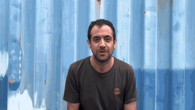a man wearing a t-shirt with a circle on the front that says ' acm '