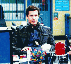 a man in a leather jacket sits at a desk with a red light on it