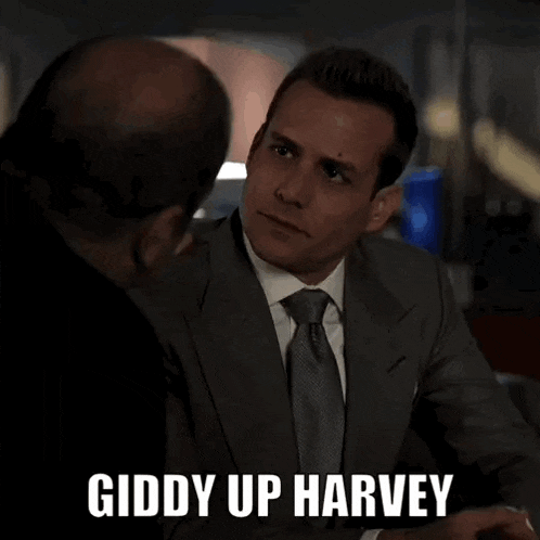 a man in a suit and tie is sitting at a table with another man .