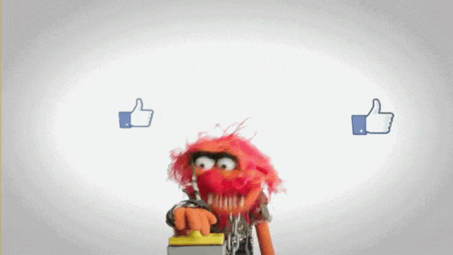 a muppet with red hair is pressing a button with two thumbs up behind it