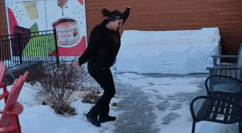 a woman is dancing in front of a sign that says tamales