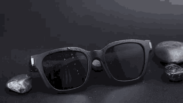 a pair of sunglasses with a blue lens sits next to a pair of glasses