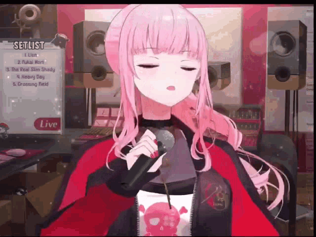 a girl with pink hair is singing into a microphone while wearing a skull shirt