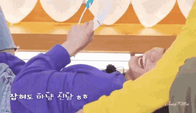 a person in a purple sweater is laying on a bed with a yellow arm around their waist .