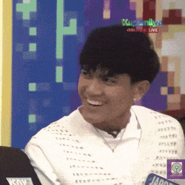 a young man is smiling in front of a screen that says ka family