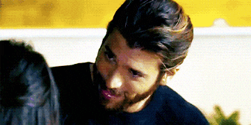a close up of a man with a beard kissing a woman