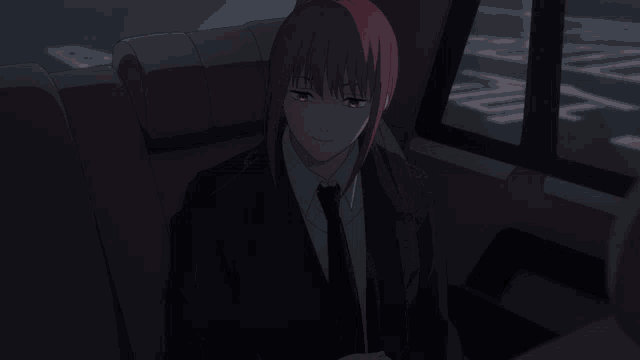 a girl with red hair is sitting in the back seat of a car with her eyes closed