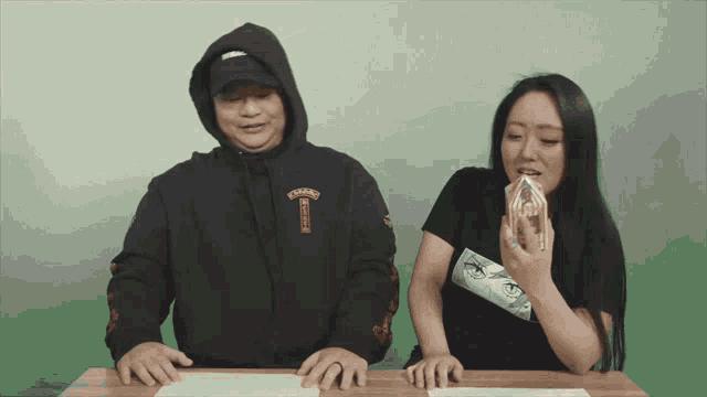 a man in a black hoodie with the letter t on the front