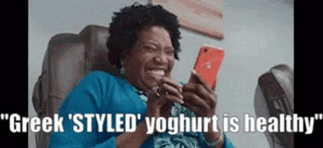 a woman is sitting in a chair looking at a cell phone .