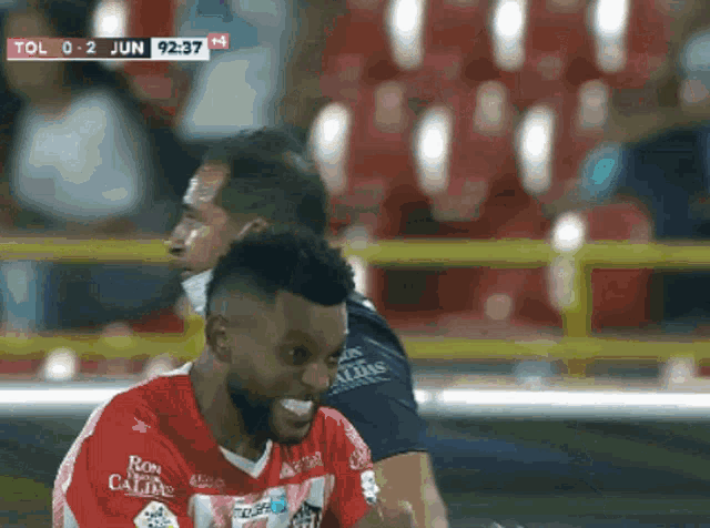 a soccer player wearing a red shirt that says ron calima