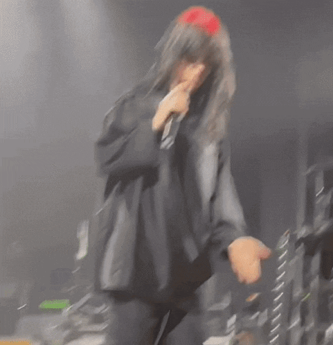 a woman in a black shirt is singing into a microphone on a stage