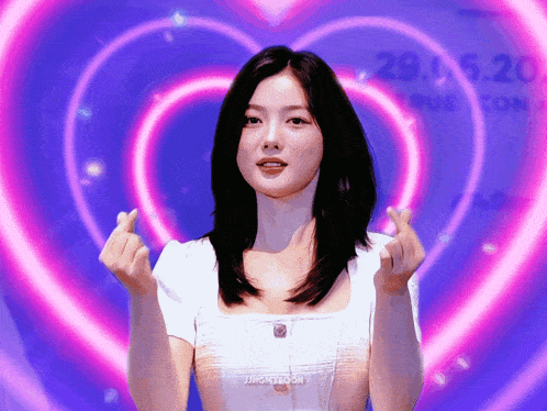 a woman is making a heart shape with her hands and the words jingkizoom are on the bottom right