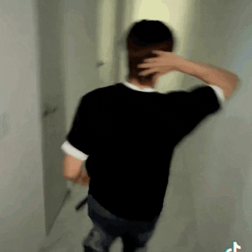 a blurry picture of a man in a black shirt standing in a doorway .