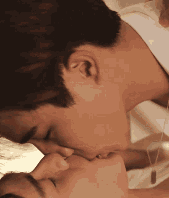 a close up of a man kissing a woman 's face