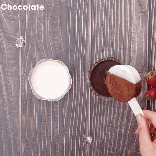 a person is dipping an ice cream bar in chocolate sauce