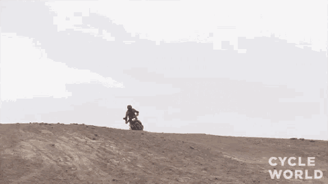 a person is riding a dirt bike on a dirt road in the desert .