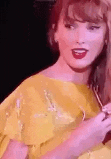 a woman in a yellow dress is holding a microphone .