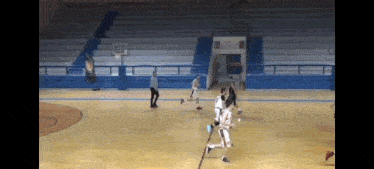 a basketball game is being played on a court with a referee watching