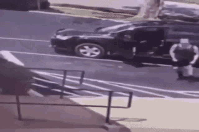 a man is getting out of a car in a parking lot next to stairs .