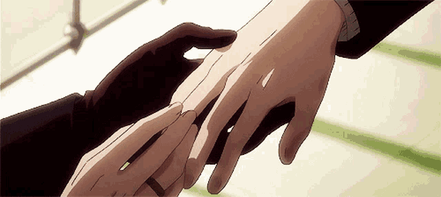 a man is putting a wedding ring on another man 's finger