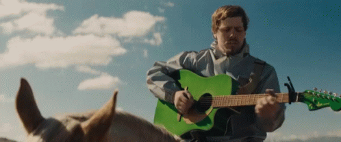 Playing Guitar Riding A Horse GIF - Playing Guitar Riding A Horse Guitarist GIFs