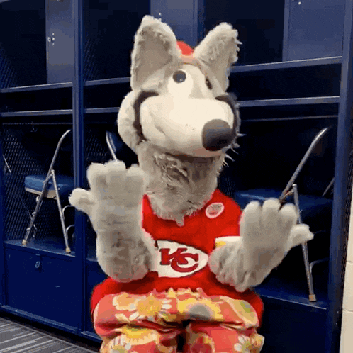 a mascot for the kansas city chiefs is sitting in a blue locker room