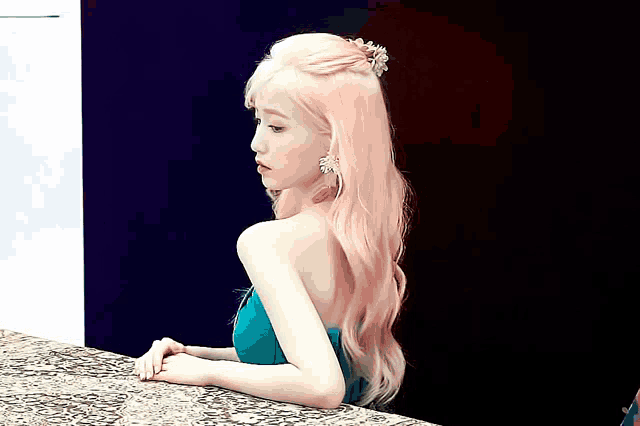 a woman with pink hair is wearing a green dress