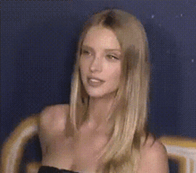 a woman with long blonde hair is wearing a strapless top