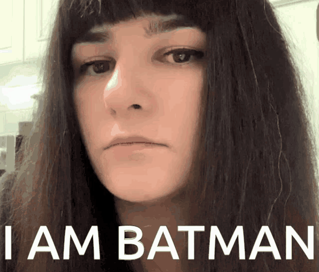 a woman with a serious look on her face and the words i am batman below her