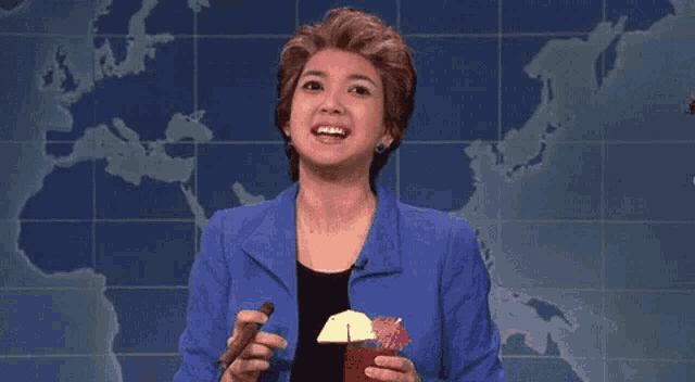 a woman in a blue suit is holding a chocolate bar and a drink .