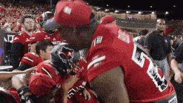 a group of football players are huddled together with one wearing a number 5 jersey