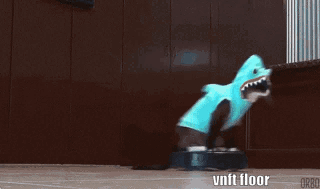 a person in a shark costume is riding a vacuum cleaner