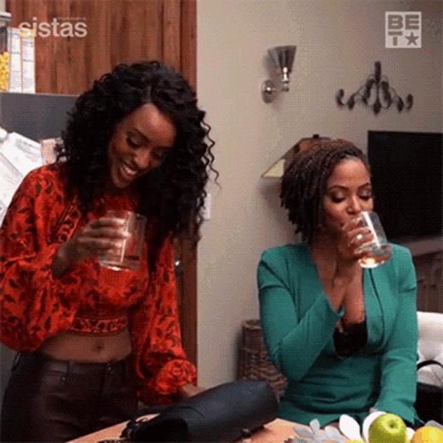 a couple of women are sitting at a table drinking wine .